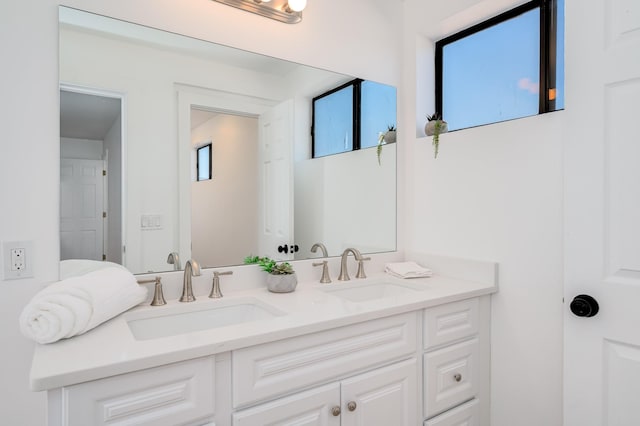 bathroom featuring a sink and double vanity