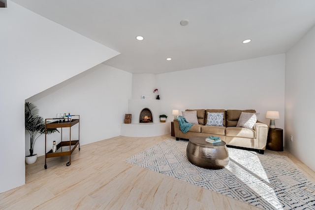 living area featuring a warm lit fireplace and recessed lighting