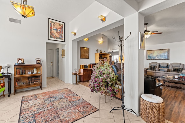 interior space featuring visible vents, a towering ceiling, and tile patterned floors