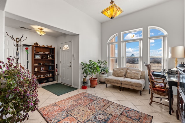 foyer entrance with light tile patterned flooring and visible vents