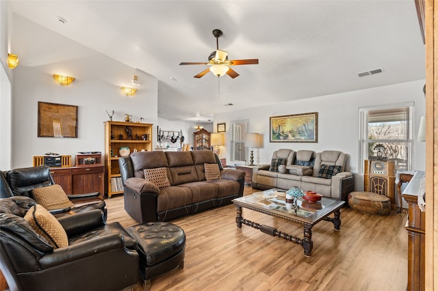 living room featuring visible vents, vaulted ceiling, light wood-style flooring, and ceiling fan