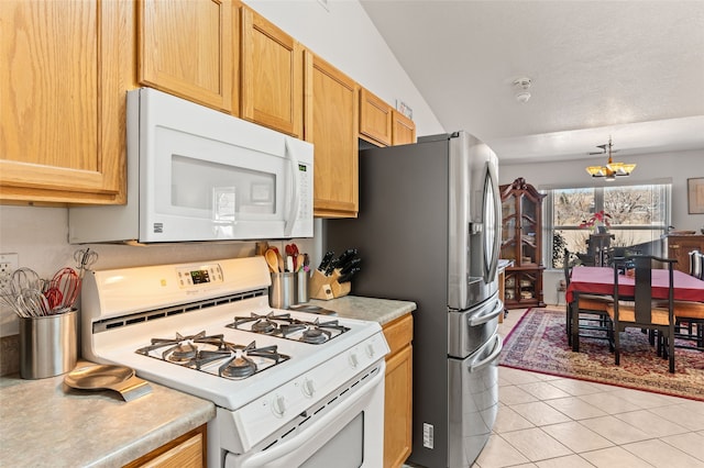 kitchen with decorative light fixtures, light tile patterned floors, light countertops, a chandelier, and white appliances