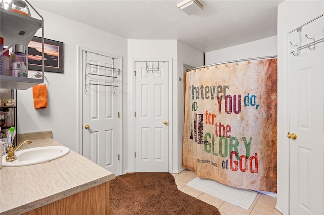 bathroom featuring curtained shower, a textured ceiling, vanity, and tile patterned floors