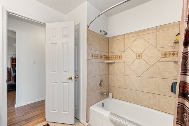 bathroom with shower / tub combo, baseboards, and wood finished floors