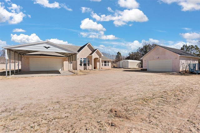 view of front of house featuring stucco siding and an outbuilding