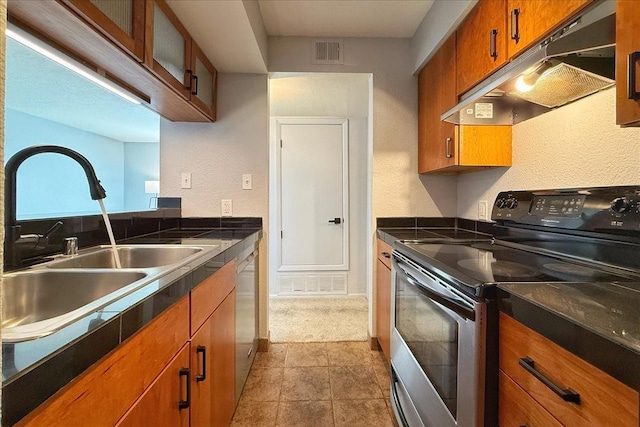 kitchen with under cabinet range hood, stainless steel appliances, a sink, visible vents, and brown cabinets