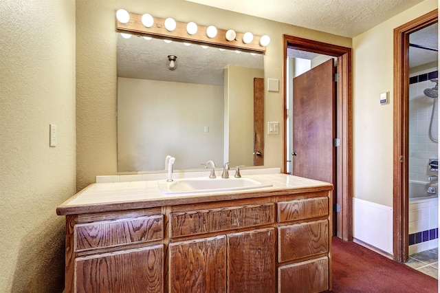 full bathroom with shower / tub combination, a textured wall, a textured ceiling, and vanity