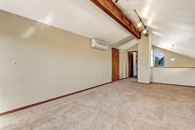 unfurnished room with carpet, lofted ceiling with beams, a textured ceiling, a wall mounted air conditioner, and baseboards