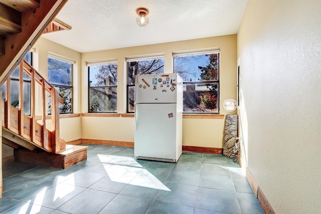 doorway to outside featuring a healthy amount of sunlight, stairway, baseboards, and tile patterned floors