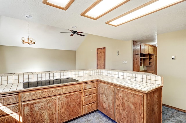 kitchen with lofted ceiling, tile countertops, and black electric stovetop