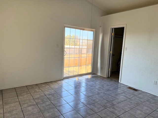 tiled spare room featuring visible vents