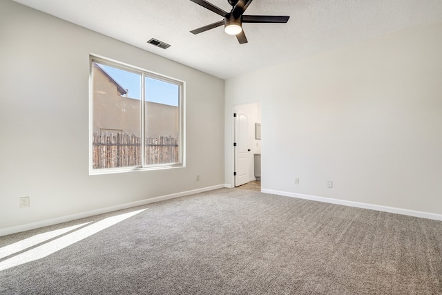 unfurnished room featuring a textured ceiling, carpet floors, visible vents, and baseboards