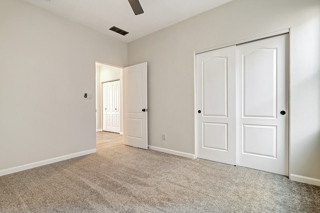 unfurnished bedroom with carpet, a closet, visible vents, and baseboards