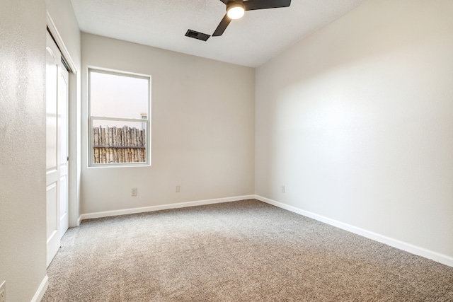 unfurnished room with visible vents, baseboards, a ceiling fan, carpet, and a textured ceiling