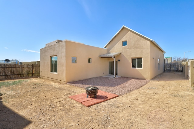 back of house with a patio, fence, a fire pit, and stucco siding