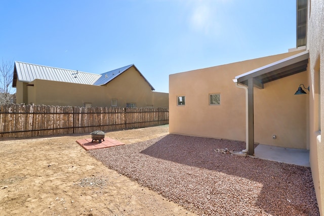 view of yard featuring a patio area, fence, and a fire pit