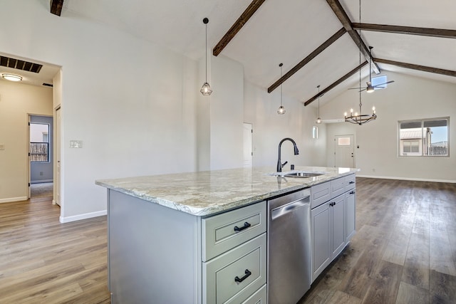 kitchen with a sink, wood finished floors, stainless steel dishwasher, and beamed ceiling