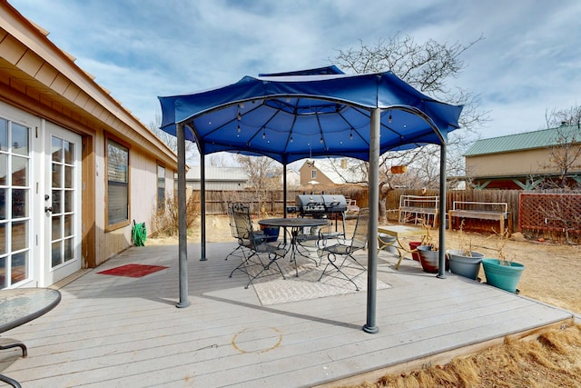 deck with french doors, outdoor dining space, and a fenced backyard