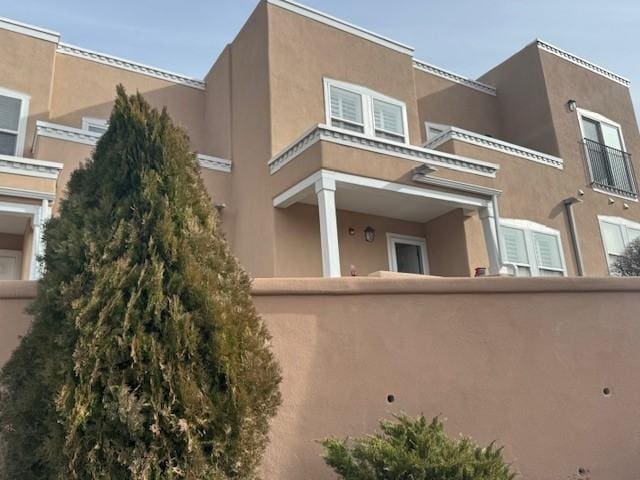 view of front of house with fence and stucco siding