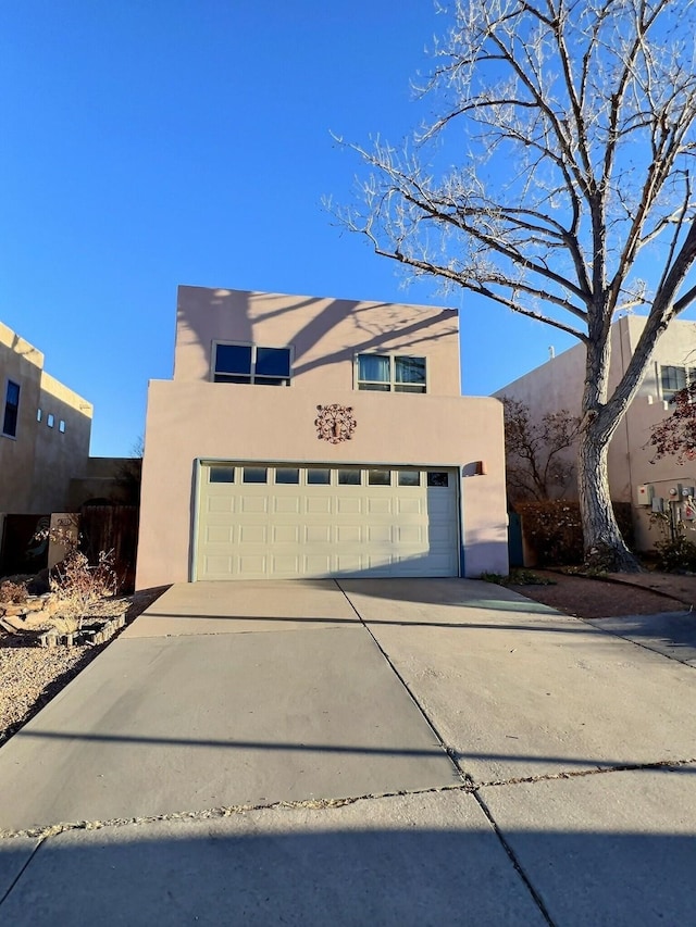 view of front of house featuring a garage, driveway, and stucco siding