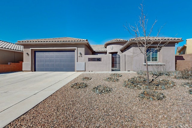 mediterranean / spanish home featuring a garage, concrete driveway, and stucco siding