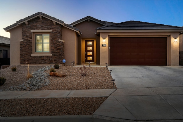 view of front facade with stone siding, driveway, an attached garage, and stucco siding