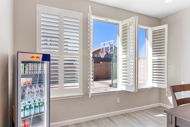 doorway to outside with wine cooler, baseboards, and wood finished floors