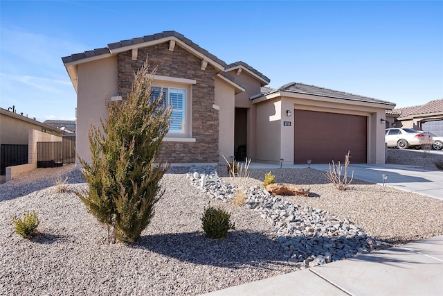 view of front of home featuring concrete driveway, stone siding, a tiled roof, an attached garage, and stucco siding