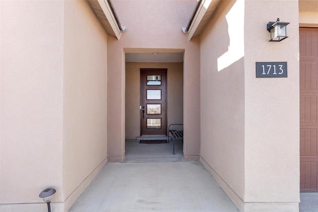 entrance to property featuring stucco siding