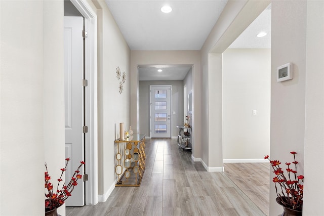 corridor featuring light wood-type flooring, baseboards, and recessed lighting