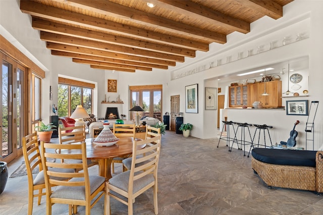 dining room with wood ceiling, beam ceiling, and french doors