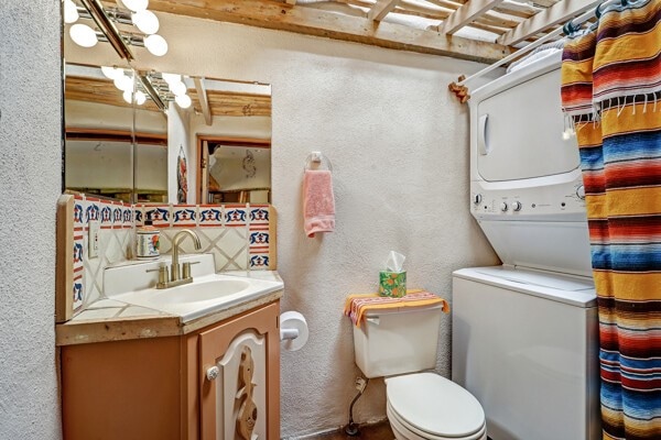 220 Irvine Unit B, Santa Fe, NM 87501 - full bathroom featuring a textured wall, toilet, vanity, and a chandelier