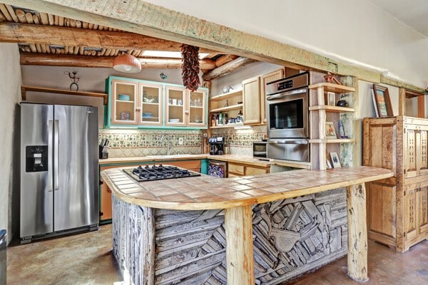 220 Irvine Unit B, Santa Fe, NM 87501 - kitchen featuring appliances with stainless steel finishes, open shelves, tile counters, tasteful backsplash, and a warming drawer
