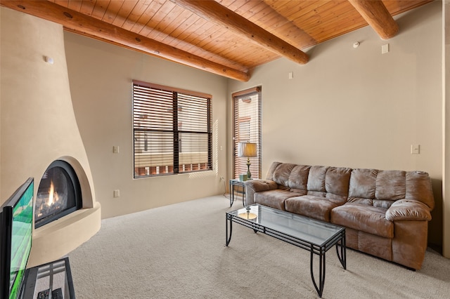 carpeted living area featuring wooden ceiling, a large fireplace, and beamed ceiling