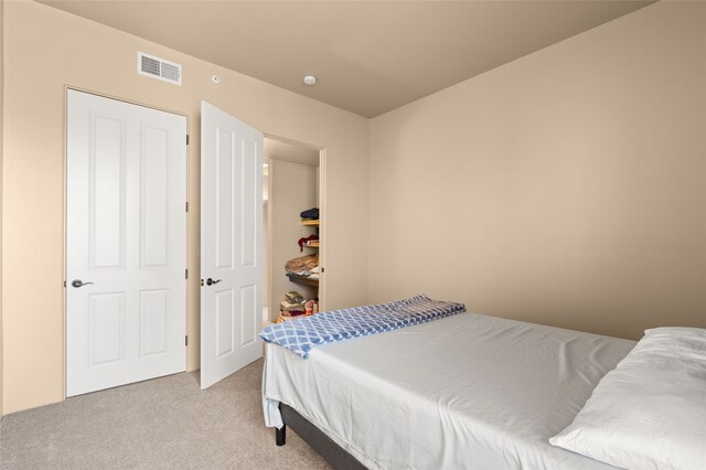 bedroom featuring visible vents and light colored carpet