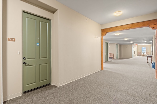 hall featuring carpet flooring and baseboards