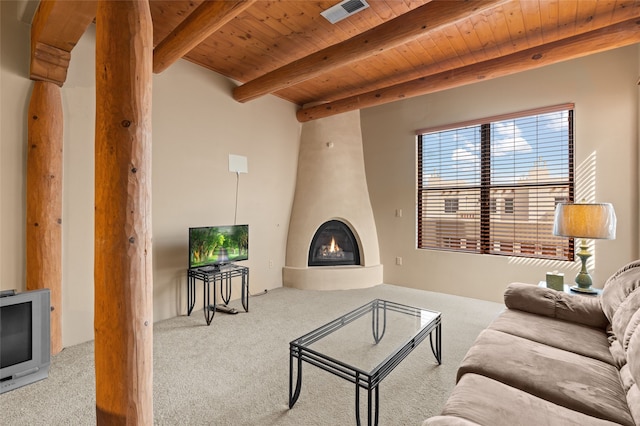 living area with wooden ceiling, a fireplace, visible vents, beam ceiling, and carpet