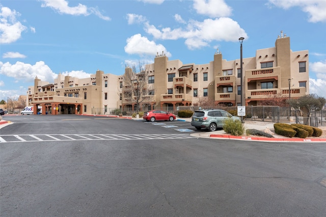 view of property featuring uncovered parking and fence