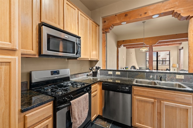 kitchen with a sink, stainless steel appliances, dark countertops, and light brown cabinets