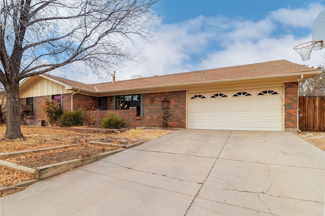 ranch-style home with concrete driveway, brick siding, an attached garage, and fence