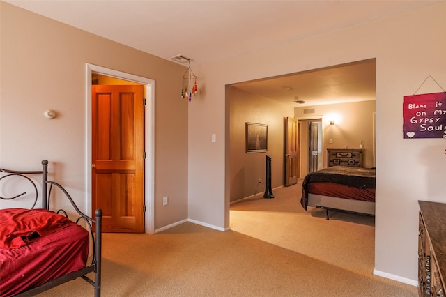 carpeted bedroom featuring baseboards and visible vents