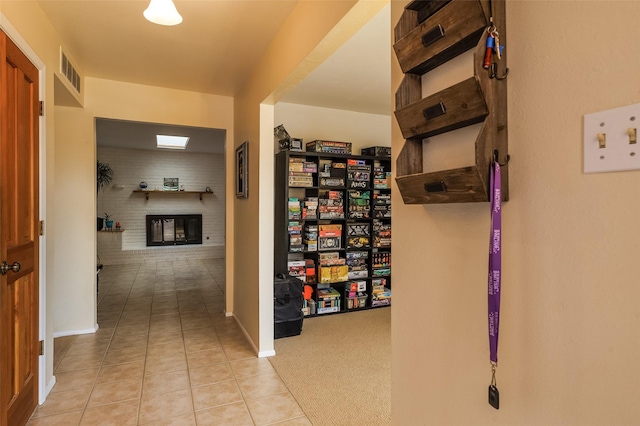 corridor with tile patterned flooring, visible vents, and baseboards