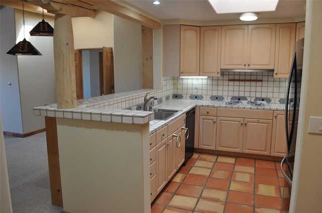 kitchen featuring black dishwasher, light brown cabinetry, a skylight, and a sink