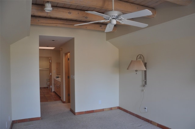 unfurnished room featuring carpet floors, wood ceiling, ceiling fan, beamed ceiling, and baseboards