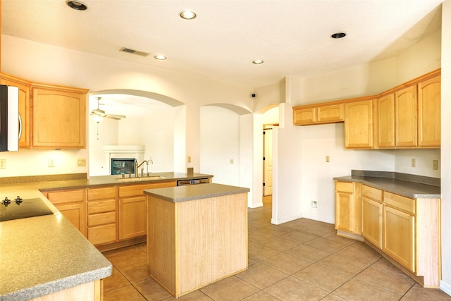 kitchen featuring visible vents, a ceiling fan, black electric stovetop, light brown cabinets, and a sink