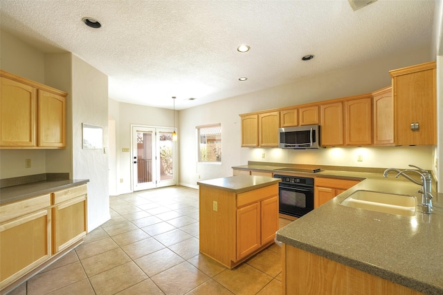 kitchen featuring light tile patterned floors, a kitchen island, a sink, a textured ceiling, and black appliances