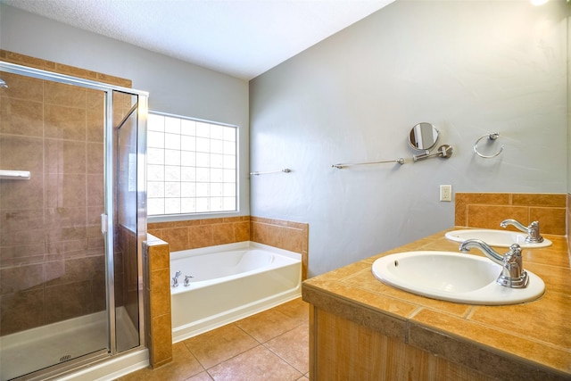 bathroom featuring tile patterned flooring, a sink, and a shower stall