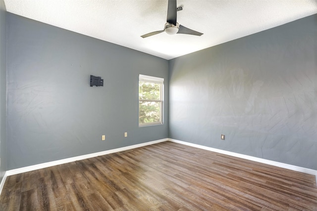 unfurnished room with a ceiling fan, a textured ceiling, baseboards, and wood finished floors