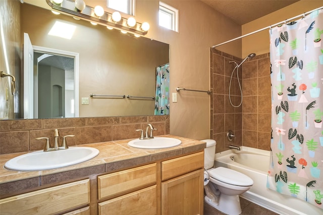 bathroom featuring double vanity, a sink, toilet, and shower / bath combo with shower curtain