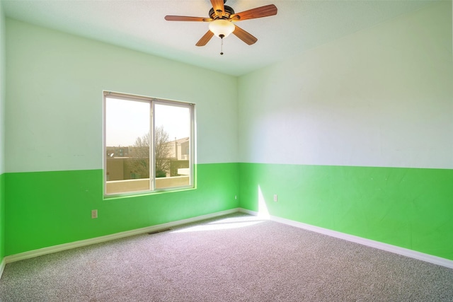 carpeted empty room featuring ceiling fan, visible vents, and baseboards